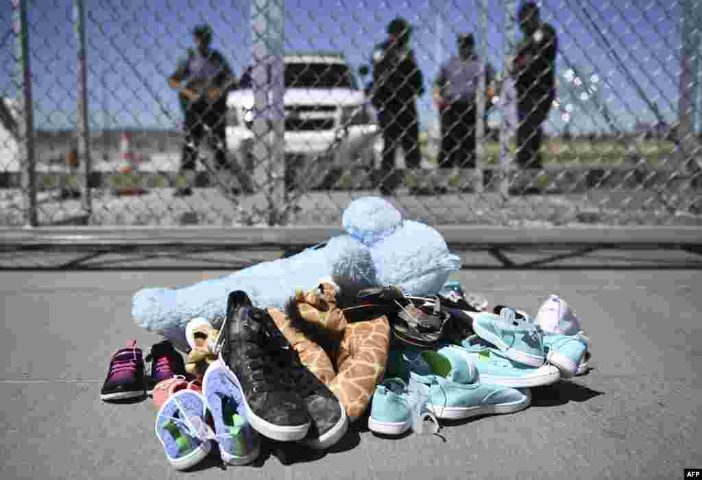 미국 텍사스주 엘패소 인근 토닐로 통관항에서 트럼프 행정부의 아동 격리 정책을 반대하는 미국 시장들이 시위하는 가운데, 시위 장소 주변에 수십 개의 신발들이 쌓여있다.