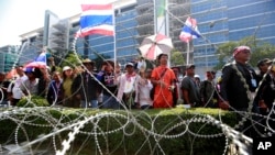 Anti-government protesters chant slogans during a rally outside the office of the permanent secretary for defense where Prime Minister Yingluck Shinawatra was reportedly working inside, Monday, Feb. 3, 2014.