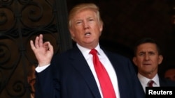 FILE - President-elect Donald Trump talks to members of the media as retired U.S. Army Lieutenant General Michael Flynn stands next to him at Mar-a-Lago estate in Palm Beach, Florida.