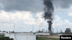 FILE - Smoke rises from a fire at Exxon Mobil's refining and chemical plant complex in Baytown, near Houston, Texas, July 31, 2019. 