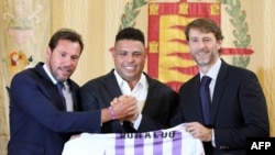 Le légendaire footballeur brésilien Ronaldo (C) brandit un maillot symbolique du Real Valladolid devant le maire de Valladolid, Oscar Puente (à gauche) et le président du Real Valladolid, Carlos Suarez, lors d'une conférence de presse à Valladolid le 3 se