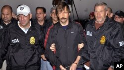 FILE - This Nov. 16, 2010, photo provided by the Drug Enforcement Administration (DEA), shows Russian arms trafficking suspect Viktor Bout, center, led by DEA officers off a flight From Bangkok to New York after his extradition to face terrorism charges.