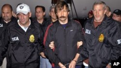 This Nov. 16, 2010, file photo, provided by the Drug Enforcement Administration (DEA), shows Russian arms trafficking suspect Viktor Bout, center, led by DEA officers off a flight From Bangkok to New York after his extradition to face terrorism charges in