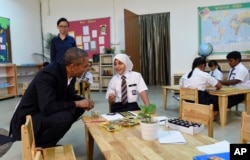 President Barack Obama listens to a girl while meeting with children during his tour to the Dignity for Children Foundation in Kuala Lumpur, Malaysia, Nov. 21, 2015.