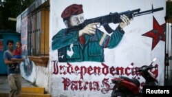 Mural que muestra a Chávez con un arma cerca de su mausoleo en Caracas.