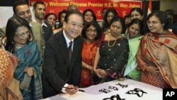 Chinese Premier Wen Jiabao writes an India-China friendship message during a visit to a school in New Delhi, India, 15 Dec. 2010.