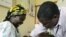 Iren Salama (left) holds her baby Pendo as it is given a malaria vaccination in a medical trial at a clinic in the Kenya coastal town of Kilifi,(file photo)