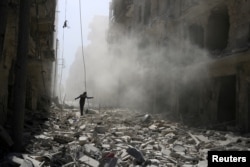 A man walks amid the rubble of damaged buildings after an airstrike on the rebel held al-Qaterji neighborhood of Aleppo, Syria, Sept. 25, 2016.