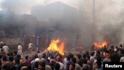 Massa yang marah membakar puluhan rumah berada di wilayah yang didominasi Kristen di Lahore, Pakistan, Sabtu (9/3).