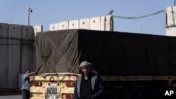 FILE - Egyptian truck drivers carrying humanitarian aid for the Gaza Strip transit through the Kerem Shalom Crossing in southern Israel, December 22, 2023.