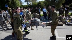 File - In this March 1, 2016 photo, American servicemen and Israeli soldiers participate in a joint drill simulating a rocket attack at a base in Hatzor, central Israel. Israel is making contingency plans to evacuate up to a quarter million people from communities along the Gaza and Lebanese borders to get them away from missile attacks if war erupts again with Hamas or Hezbollah. 