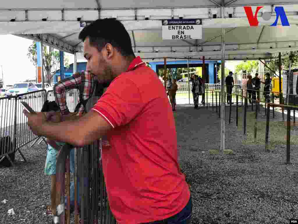 Venezolanos esperan para entrar al Centro de Recepción de Migrantes, administrado por ACNUR, en Pacaraima, Brasil. Foto: Celia Mendoza - VOA.