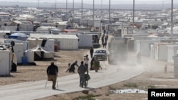 FILE - Syrian refugees walk at the Al Zaatari refugee camp in the Jordanian city of Mafraq, near the border with Syria, Dec. 7, 2014.