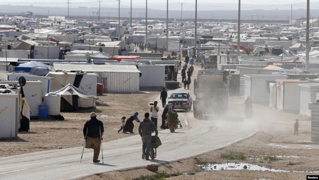 Syrian refugees walk at the Al Zaatari refugee camp in the Jordanian city of Mafraq, near the border with Syria, December 7, 2014.