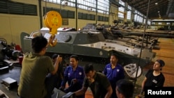 Sejumlah pekerja perusahaan produsen peralatan militer PT Pindad di Bandung, Jawa Barat, sedang berdiskusi, 16 Maret 2015. Indonesia memberikan bantuan peralatan militer buatan PT Pindad senilai $500.000 atau Rp 7,7 miliar kepada militer Kamboja. (Foto: Beawiharta/Reuters)