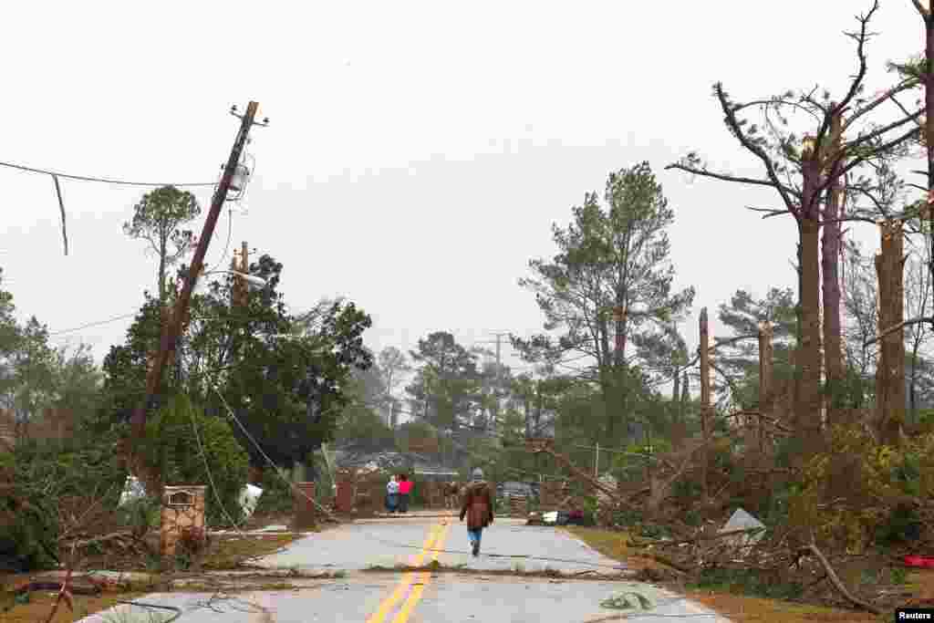 Warga setempat memeriksa kerusakan setelah angin puting beliung (tornado) melanda Albany, negara bagian Georgia, AS.