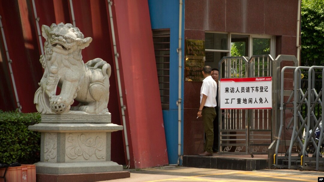 A man stands at the entrance gate of a Huajian Group shoe factory in Ganzhou, in southeastern China's Jiangxi Province, June 6, 2017. 