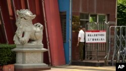 A man stands at the entrance gate of a Huajian Group shoe factory in Ganzhou, in southeastern China's Jiangxi Province, June 6, 2017. 