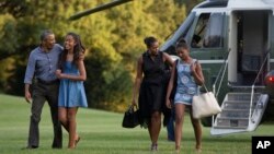 De izquierda a derecha, el presidente Obama, su hija Malia, la primera dama Michelle y su otra hija, Sasha, regresan de sus vacaciones en Martha's Vineyard, Massachusetts.