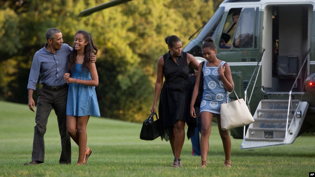 FILE - From left, President Barack Obama with daughter Malia and first lady Michelle Obama with daughter Sasha, walk form Marine One across the South Lawn of the White House in Washington, Aug. 23, 2015.