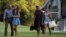 FILE - From left, President Barack Obama with daughter Malia and first lady Michelle Obama with daughter Sasha, walk from Marine One across the South Lawn of the White House in Washington, Aug. 23, 2015.