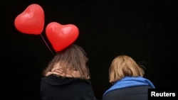 El Día de San Valentín se celebra alrededor de todo el mundo, incluso en una ciudad como Kiev, en medio de la guerra. En la imagen, dos mujeres caminan y una de ellas lleva globos en forma de corazones el 14 de febrero de 2023.