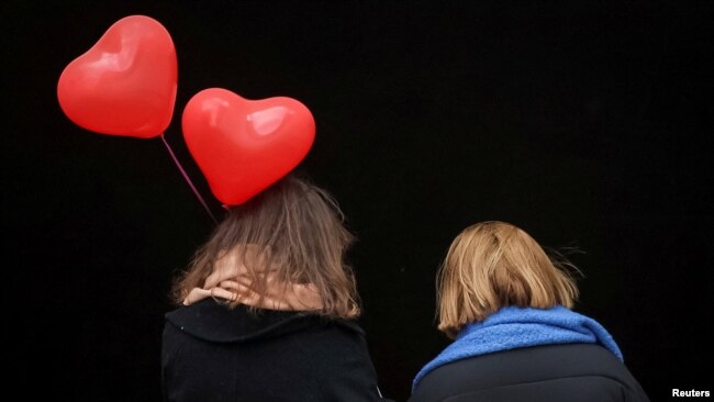 El Día de San Valentín se celebra alrededor de todo el mundo, incluso en una ciudad como Kiev, en medio de la guerra. En la imagen, dos mujeres caminan y una de ellas lleva globos en forma de corazones el 14 de febrero de 2023.