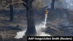 A CFA firefighter sprays water after a fire impacted Clovemont Way, Bundoora in Melbourne, Australia, December 30, 2019. 