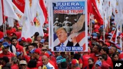 Para pendukung Presiden Nicolas Maduro melakukan unjuk rasa di Caracas hari Senin (4/2), sambil membawa gambar Presiden AS Donald Trump dengan tulisan: Keluar dari Gedung Putih, Donald Trump, Anda dan Tembok Anda! (Foto: AP).