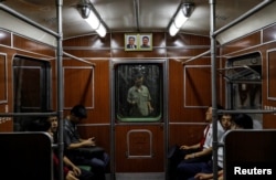 FILE - Portraits of late North Korean leaders Kim Il Sung and Kim Jong Il are seen on a train as it leaves a subway station in Pyongyang, North Korea, Sept. 11, 2018.