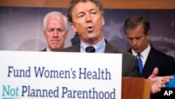 El senador y candidato presidencial, Rand Paul, habla detran de un rótulo que lee "Fondos para la salud femenina, no para Planned Parenthood".