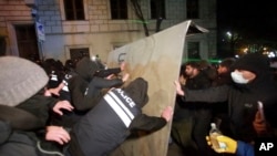 Police try to block protesters who poured into the streets following the government's announcement that it would suspend talks on European Union accession, outside the parliament building in Tbilisi, Georgia, Nov. 29, 2024. 