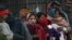 FILE - Indian homeless people wait for free food outside a temple, in New Delhi, India, Jan. 1, 2013.