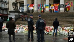La police patrouille l'un des lieux en hommage aux victimes des récentes attaques de Bruxelles à la Place de la Bourse à Bruxelles, 25 mars 2016.