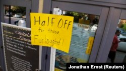 FILE - A sign at a fitness studio advertises a deal for furloughed government workers in the Capitol Hill neighborhood in Washington, Oct. 5, 2013. A government shutdown can hurt local businesses, said Ellen Zentner of the American Bankers Association.