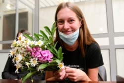 FILE - Russian journalist Svetlana Prokopyeva holds flowers after a court session in Pskov, Russia, July 6, 2020. A court in Pskov convicted her on charges of condoning terrorism and ordered her to pay a fine.