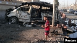 A boy stands at the site of a car bomb explosion in Sadr City, northeastern Baghdad, October 28, 2012.