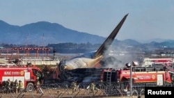 Para petugas damkar memadamkan api yang membakar pesawat Jeju Air di Bandara Muan, Provinsi Jeolla Selatan, Korea Selatan, Minggu, 29 Desember 2024. (Foto: Yonhap via Reuters)