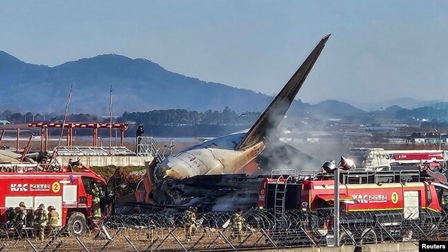 Para petugas damkar memadamkan api yang membakar pesawat Jeju Air di Bandara Muan, Provinsi Jeolla Selatan, Korea Selatan, Minggu, 29 Desember 2024. (Foto: Yonhap via Reuters)