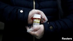 A woman holds a hydroxychloroquine prescription in Seattle, Washington, U.S. March 31, 2020. REUTERS/Lindsey Wasson