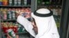 Warga Kuwait Abu Yousif membeli sekaleng bir non-alkohol dari sebuah toko kelontong kecil di pusat kota Kuwait pada 20 April. (Foto: Reuters)