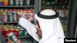 Warga Kuwait Abu Yousif membeli sekaleng bir non-alkohol dari sebuah toko kelontong kecil di pusat kota Kuwait pada 20 April. (Foto: Reuters)