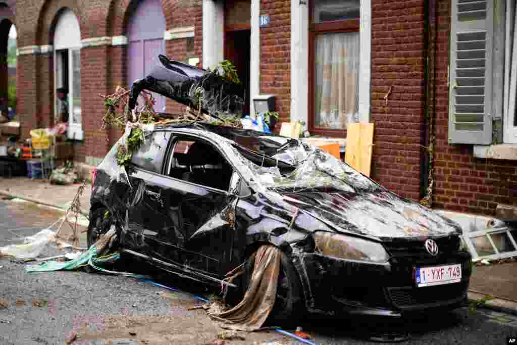 A car is strewn with debris in a residential street after flooding in Ensival, Verviers, Belgium.