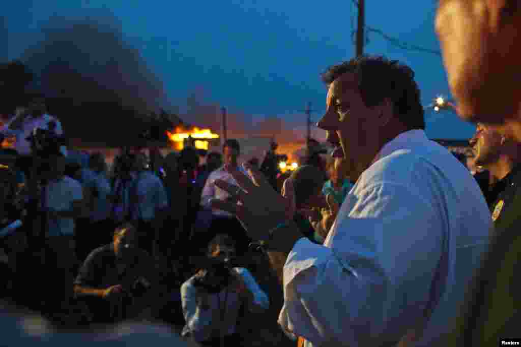 New Jersey Governor Chris Christie speaks with the media while firefighters work to control a massive fire in Seaside Park, Sept. 12, 2013. 