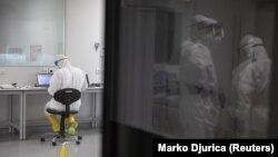 Arhiva - Zaposleni u laboratoriji za analizu uzoraka na Kovid 19 "Vatreno oko", 12. maja 2020. (REUTERS/Marko Djurica)