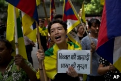 FILE - Exile Tibetans shout slogans during a protest to show support with India on Doklam standoff in New Delhi, India, Aug. 11, 2017.