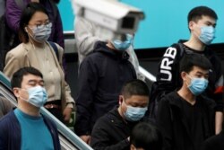 People wearing face masks are seen near a surveillance camera inside a subway station in Beijing, as the spread of the novel coronavirus disease (COVID-19) continues in the country, April 7, 2020.