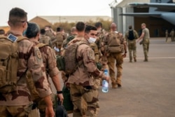 FILE - French Barkhane force soldiers who wrapped up a four-month tour of duty in the Sahel board a U.S. Air Force C130 transport plane, in Gao, Mali, June 9, 2021.