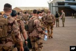 FILE - French Barkhane force soldiers who wrapped up a four-month tour of duty in the Sahel board a U.S. Air Force C130 transport plane, in Gao, Mali, June 9, 2021.