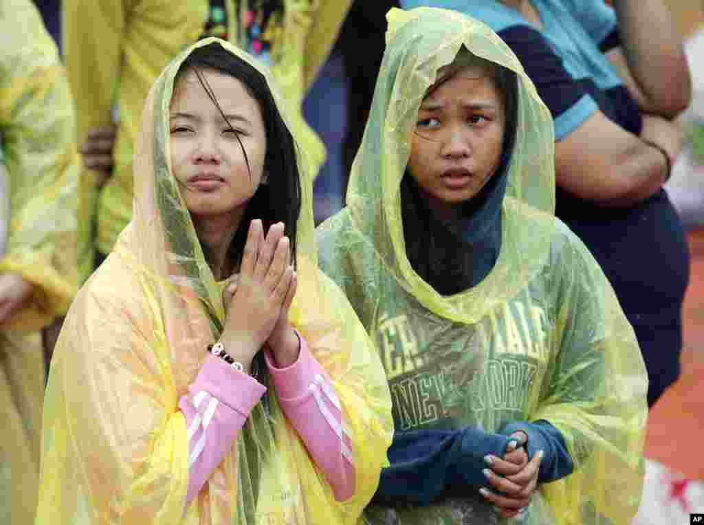 Young Filipino women pray during the visit of Pope Francis at the University of Santo Tomas in Manila, Jan. 18, 2015.